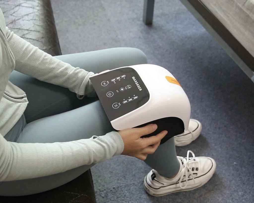 Person sitting on a bench using a knee massager on their leg